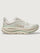Chunky soled white Hoka running shoe with pastel green trim. 