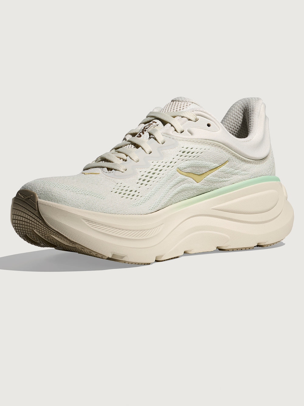 Chunky soled white Hoka running shoe with pastel green trim. 