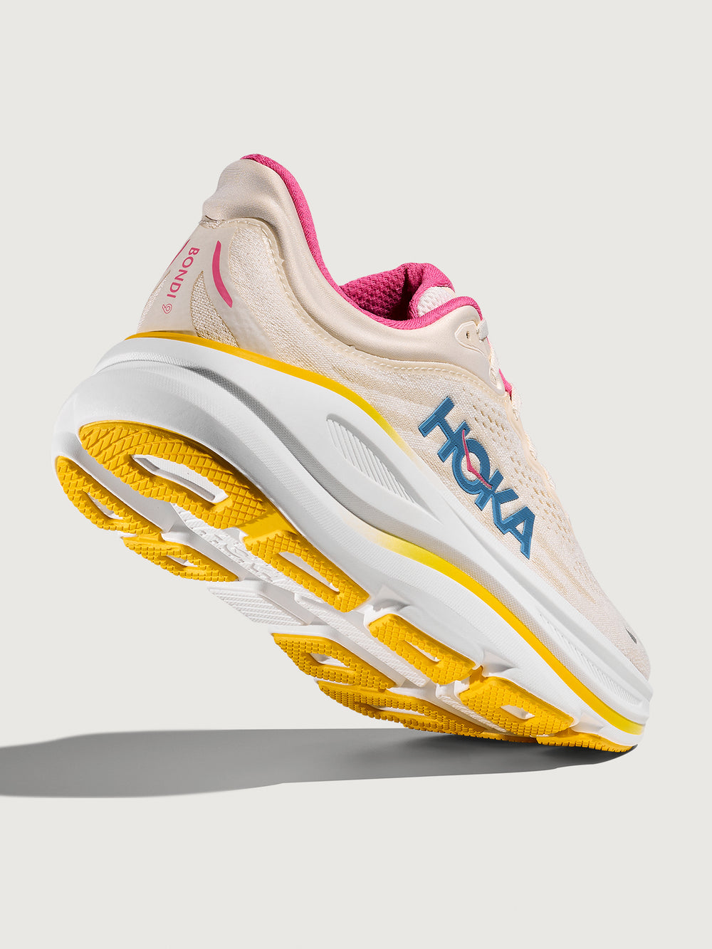 Bondi 9 Max Cushion Running Shoe in Alabaster/Birch, angled back view showing outsole traction and heel support.