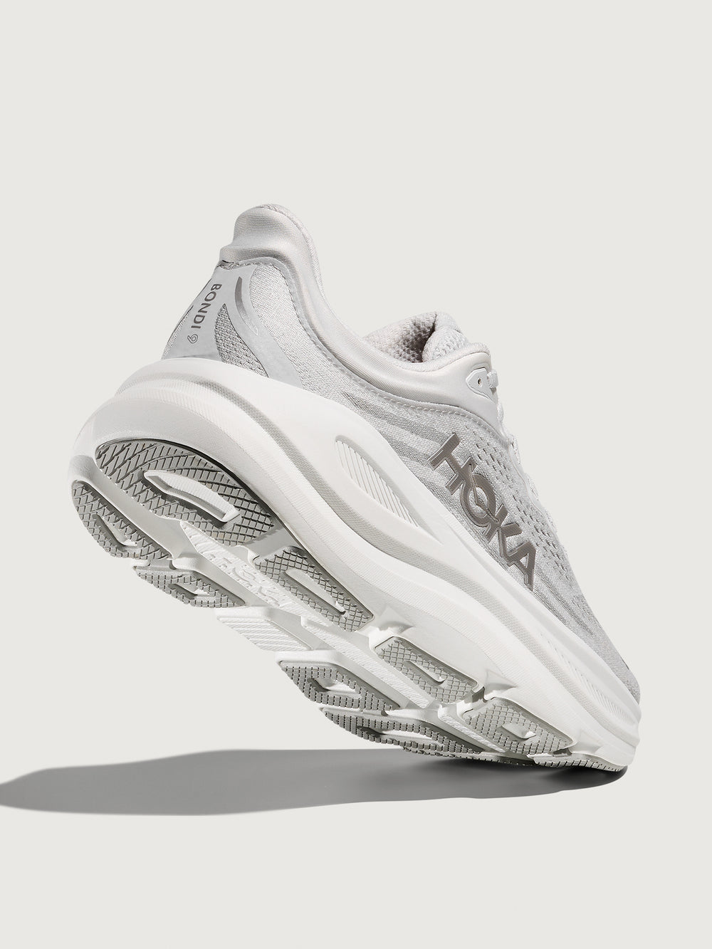 White/grey running shoe with 'Hoka' branding.