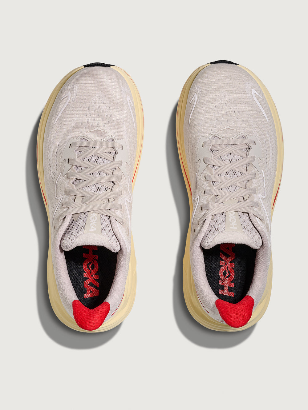 Gray running shoe with red accents with 'Hoka' logo on the side.