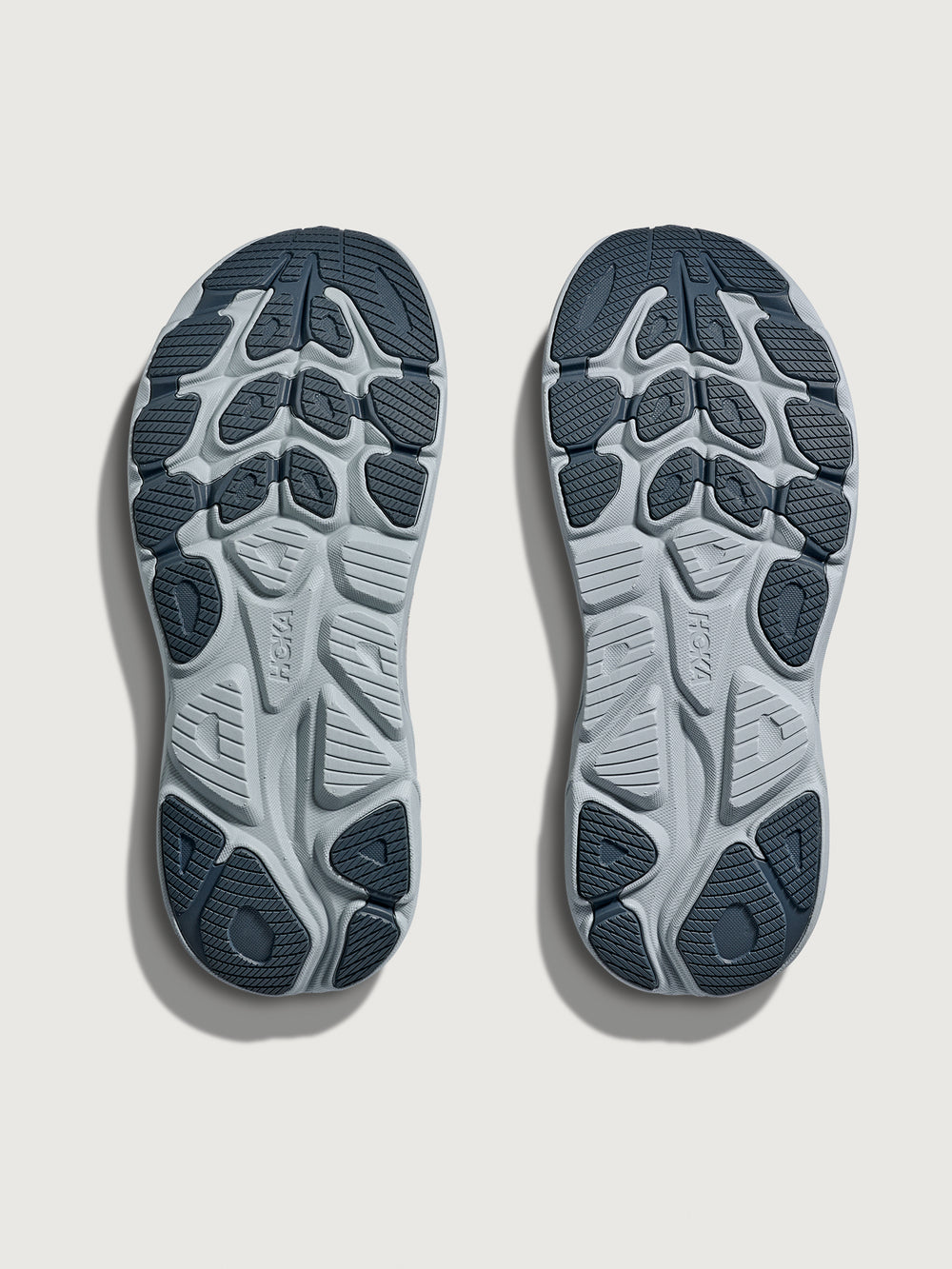 Clifton 10 Max Cushion Running Shoe in Grout/Mineral Blue, outsole view showing traction pattern and rubber coverage.