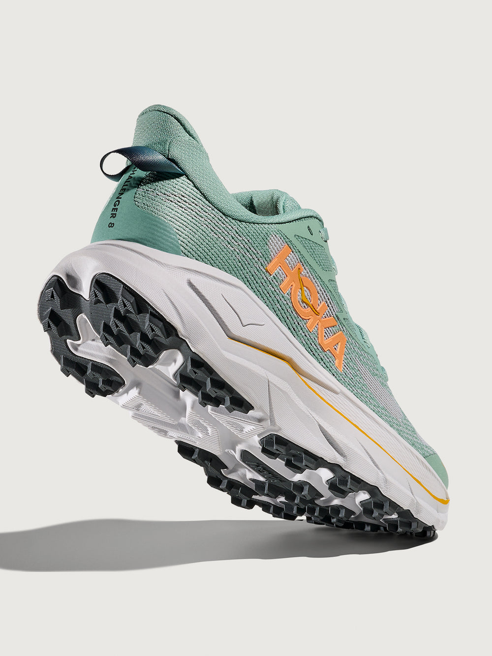 Jade and Grey running shoe with 'Hoka' branding in orange.