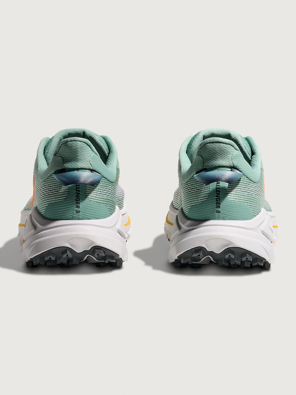 Jade and Grey running shoe with 'Hoka' branding in orange.