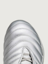 Close-up of silver metallic padded upper, toe detail.