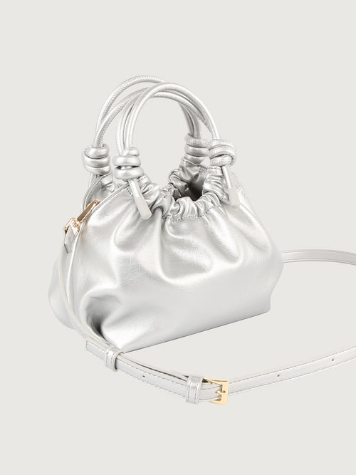 Silver mini handle bag with magnetic closure and knotted detailing on the handles.