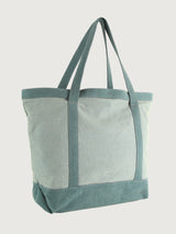 Tote bag with green straps and trim on a light gray background