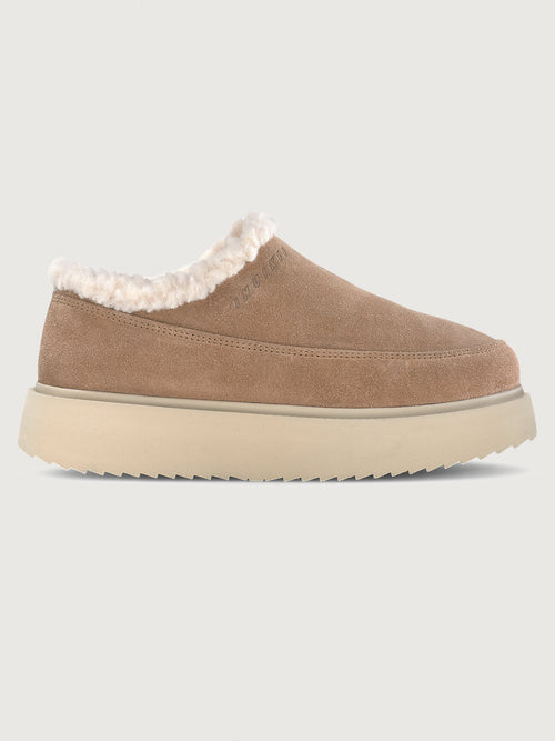 Brown slip-on shoe with white fur lining on a beige background