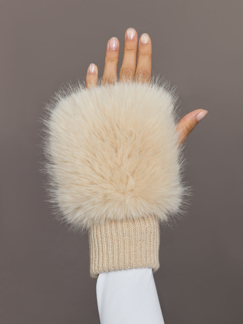 Close-up of beige faux fox knit mitten with ribbed cuff, front view.