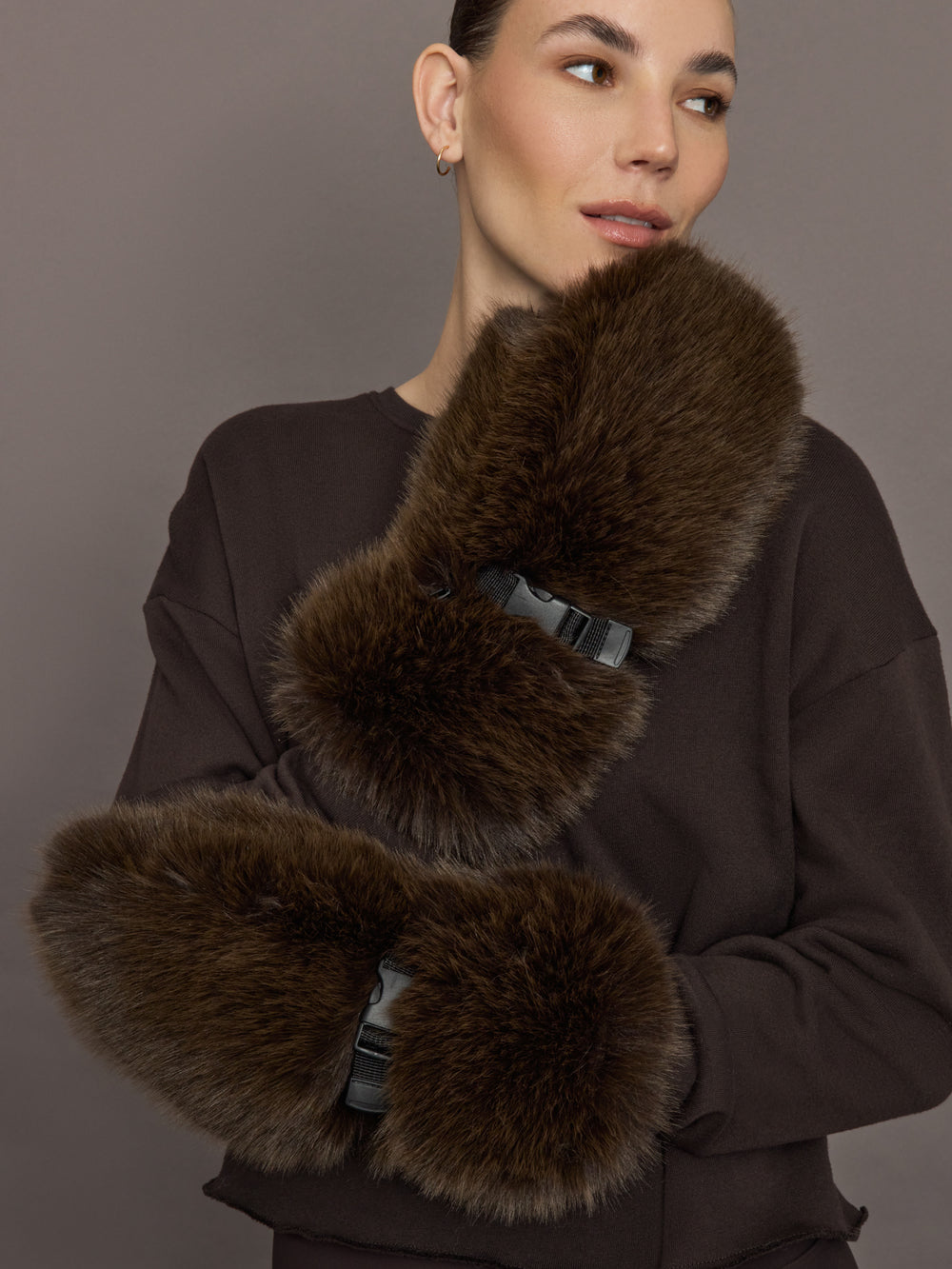 Model is wearing the Faux Fur Fox Mittens Chocolate, styled view showing both mittens.