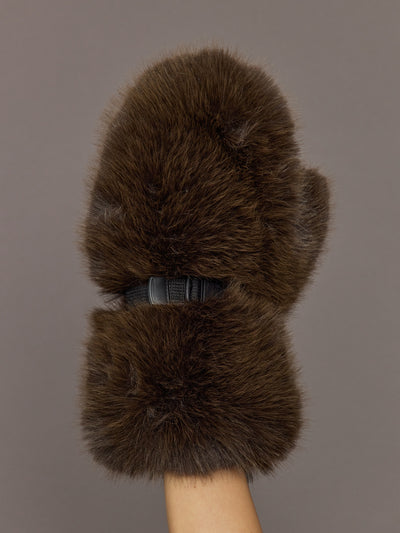 Model is holding the Faux Fur Fox Mitten Chocolate, front view of the faux fur exterior.