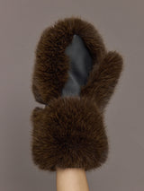 Model is holding the Faux Fur Fox Mitten Chocolate, close up of the textured palm side.