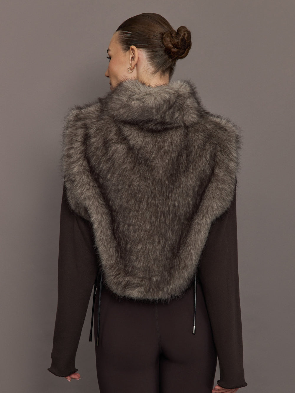 Model is wearing the Faux Fur Pullover Vest with Side Ties Mocha, back view.