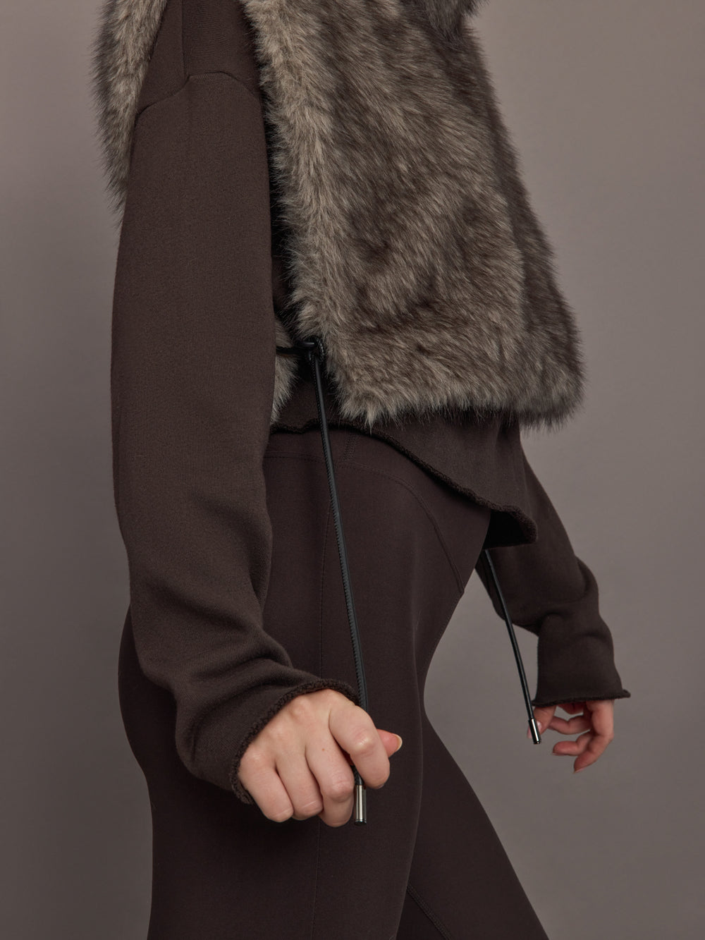 Model is wearing the Faux Fur Pullover Vest with Side Ties Mocha, close up of the side tie detail.