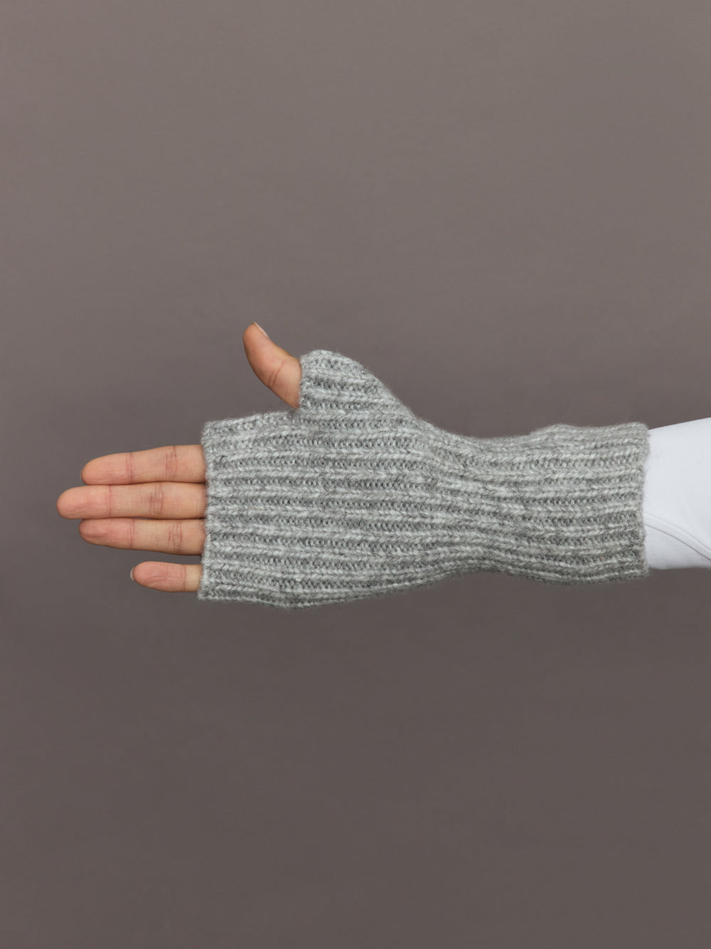 Side view of light grey ribbed fingerless knit glove with open fingertips.
