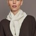 Model is wearing Knit Triangle Pull Thru Scarf with Hand Sewn Beads in ivory, front view.