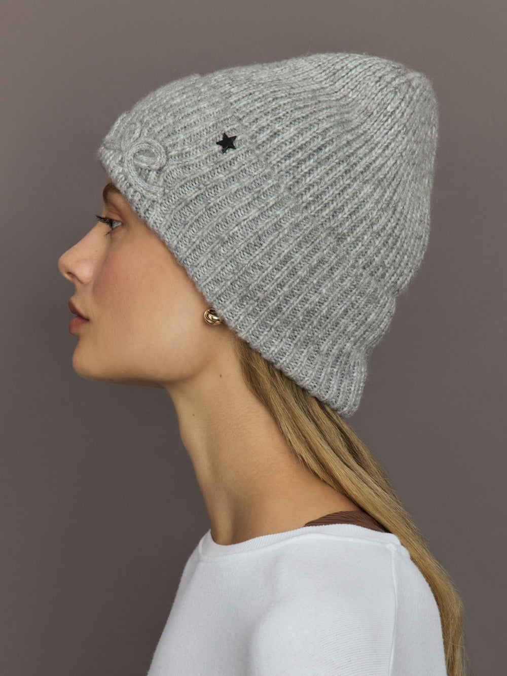 Side view of Love embroidered light grey knit hat with star detail.