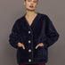 Model wearing navy faux fur cardigan with jeweled buttons, front view.