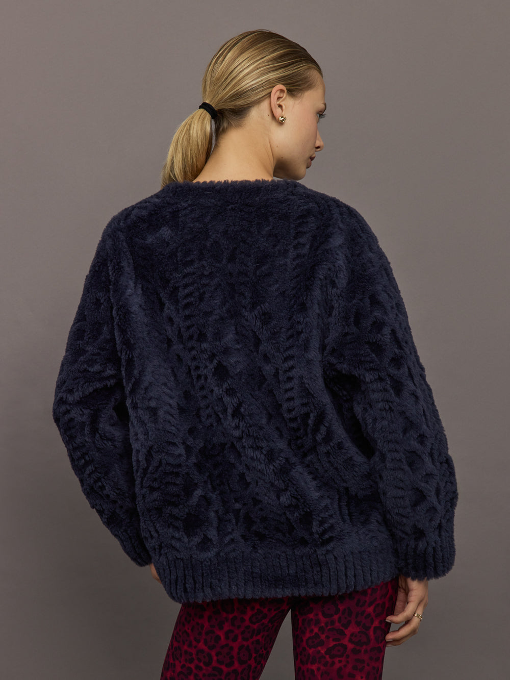 Back view of navy faux fur cardigan showing textured faux fur design.