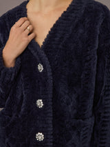 Close-up of navy faux fur cardigan with jeweled crystal button details.