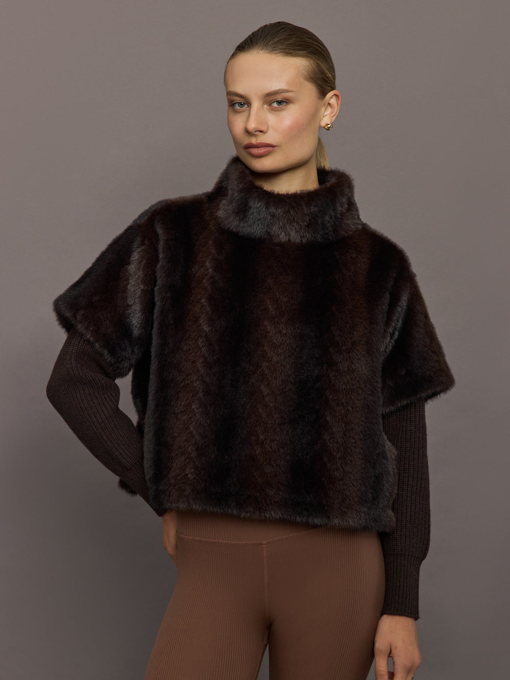 Model wearing dark brown faux fur pullover sweatshirt, front view close-up.