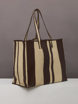 Beige canvas tote bag with black leather bindings, two straps, and an inner pocket.
