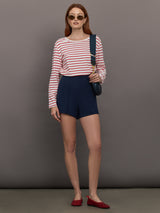 Model wears long-sleeve t-shirt with horizontal white and red stripes and a crew neckline.