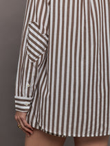 Model wears brown and white striped button-down shirt with a relaxed fit, long sleeves.