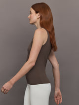 Model wears sleeveless tank top in a cocoa brown, featuring a scoop neckline and fitted silhouette and white heart in the upper center.