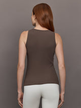 Model wears sleeveless tank top in a cocoa brown, featuring a scoop neckline and fitted silhouette and white heart in the upper center.
