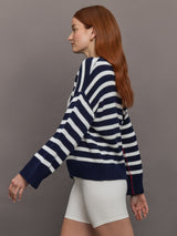 Model wears sweater in indigo and white featuring an abstract, imperfect heart design on the front, with long sleeves and a relaxed fit.