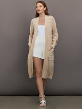 Model wears long, lightweight duster-style sweater in a natural beige tone.