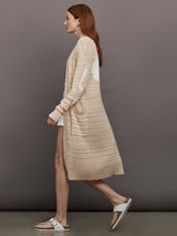 Model wears long, lightweight duster-style sweater in a natural beige tone.