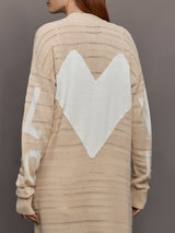 Model wears long, lightweight duster-style sweater in a natural beige tone.