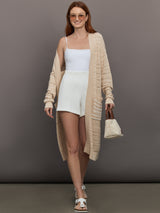 Model wears long, lightweight duster-style sweater in a natural beige tone.