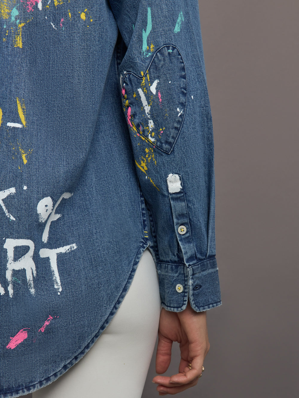 Blue denim shirt with paint splashes and text on a gray background
