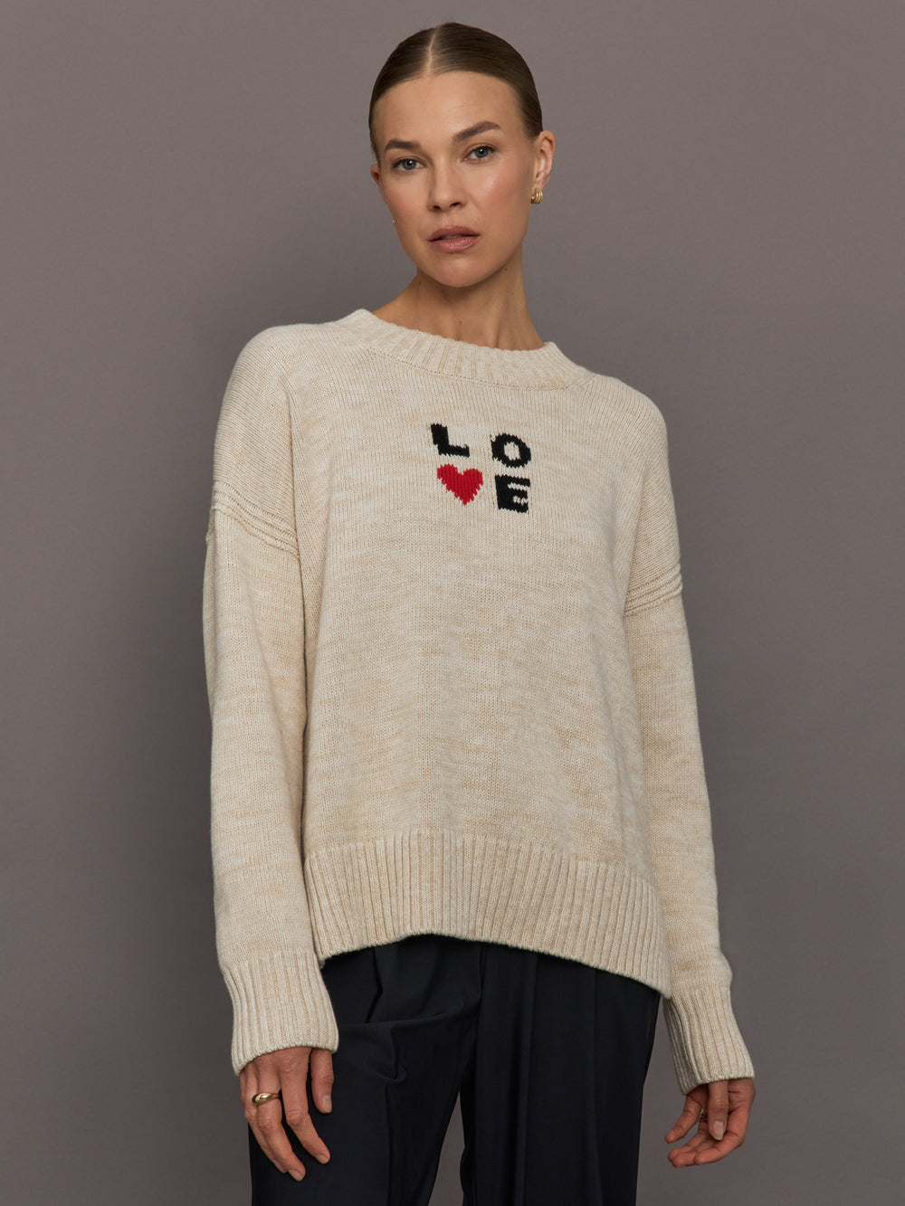 Beige sweater with 'LOVE' text and red heart design.