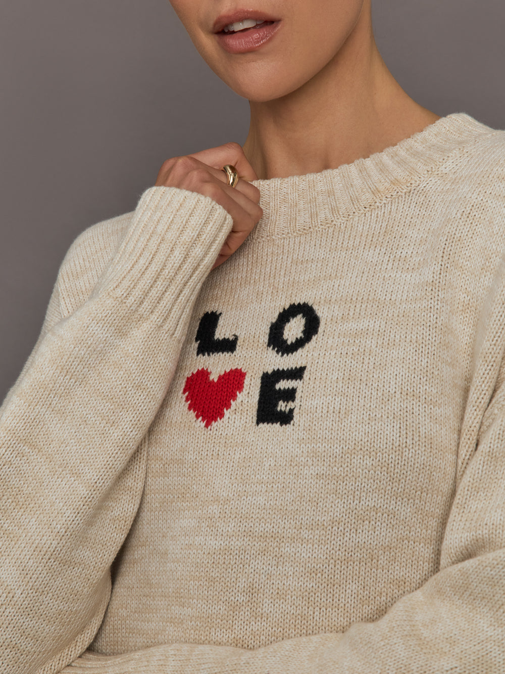 Beige sweater with 'LOVE' text and red heart design.