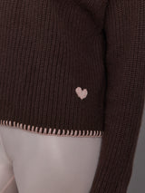 Brown ribbed sweater with a heart design on the bottom of the sweater