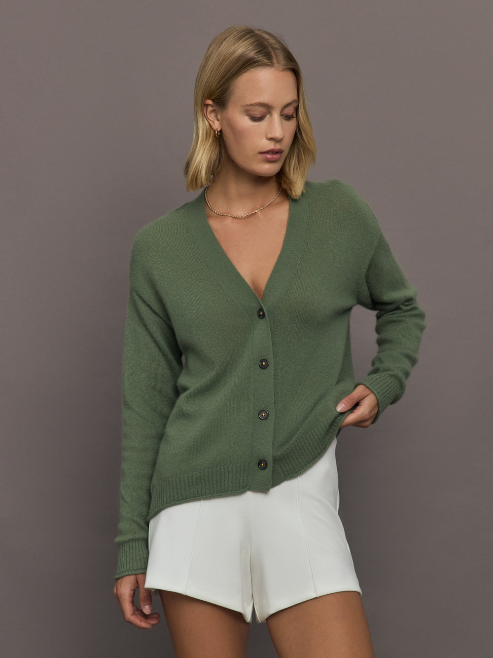 Woman wearing a green cardigan with a deep v neck. 
