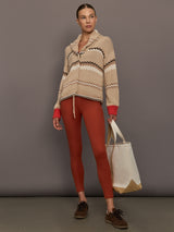 Beige knitted cardigan with patterned design and red cuffs on a neutral background
