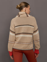 Beige knitted cardigan with patterned design and red cuffs on a neutral background