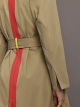 Beige trench coat with red stripe and yellow belt on a gray background