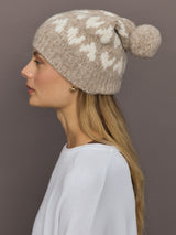 Side view of camel beanie with pom pom and heart motif.