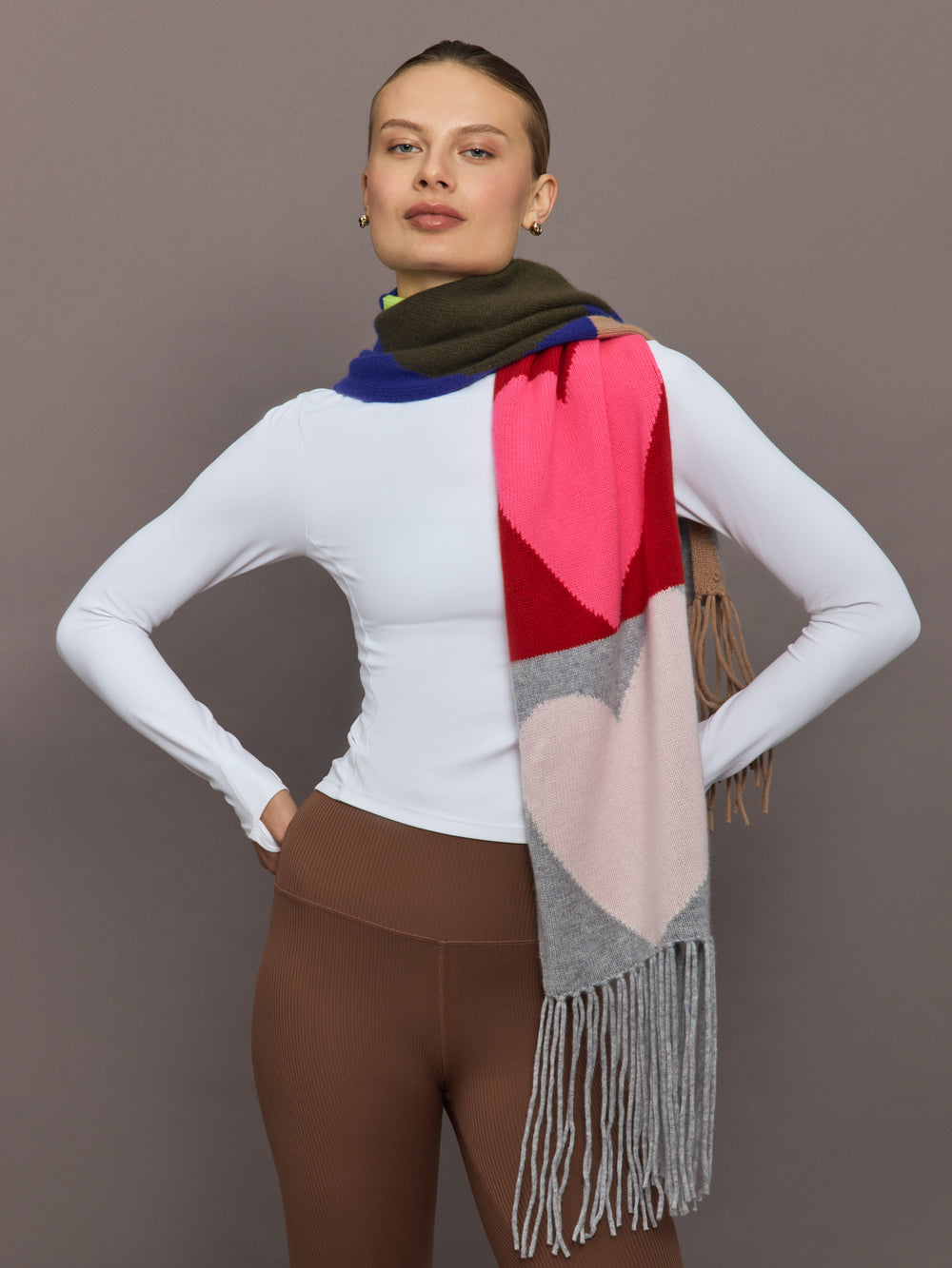 Model wearing multi-color scarf wrapped around neck, front view with fringe detail.