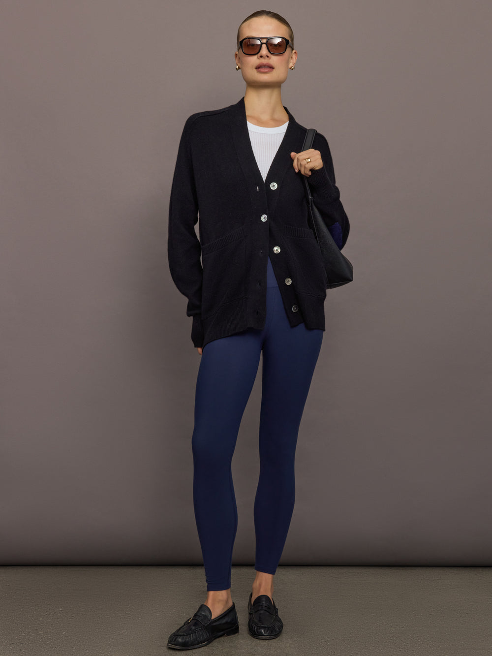 Full-body view of model wearing black cardigan with navy leggings.