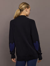 Back view of black cardigan highlighting navy heart elbow patches.