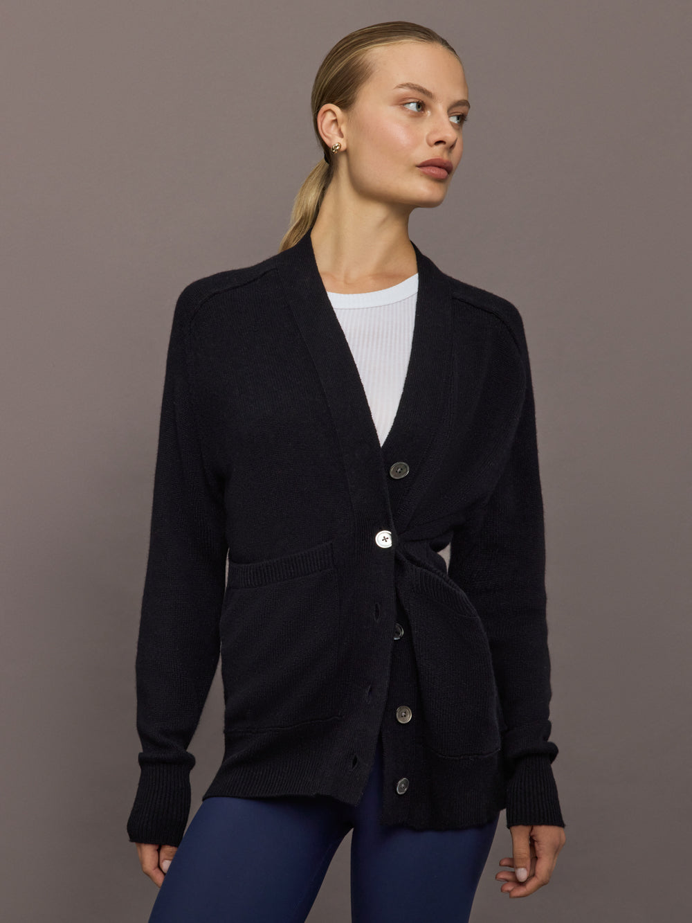 Model wearing black cardigan buttoned at waist, front view.