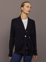 Model wearing black cardigan buttoned at waist, front view.