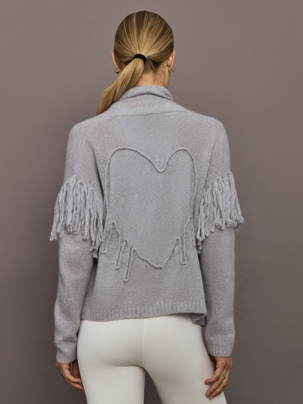 Back view of platinum cardigan showing embroidered heart motif and fringe sleeves.